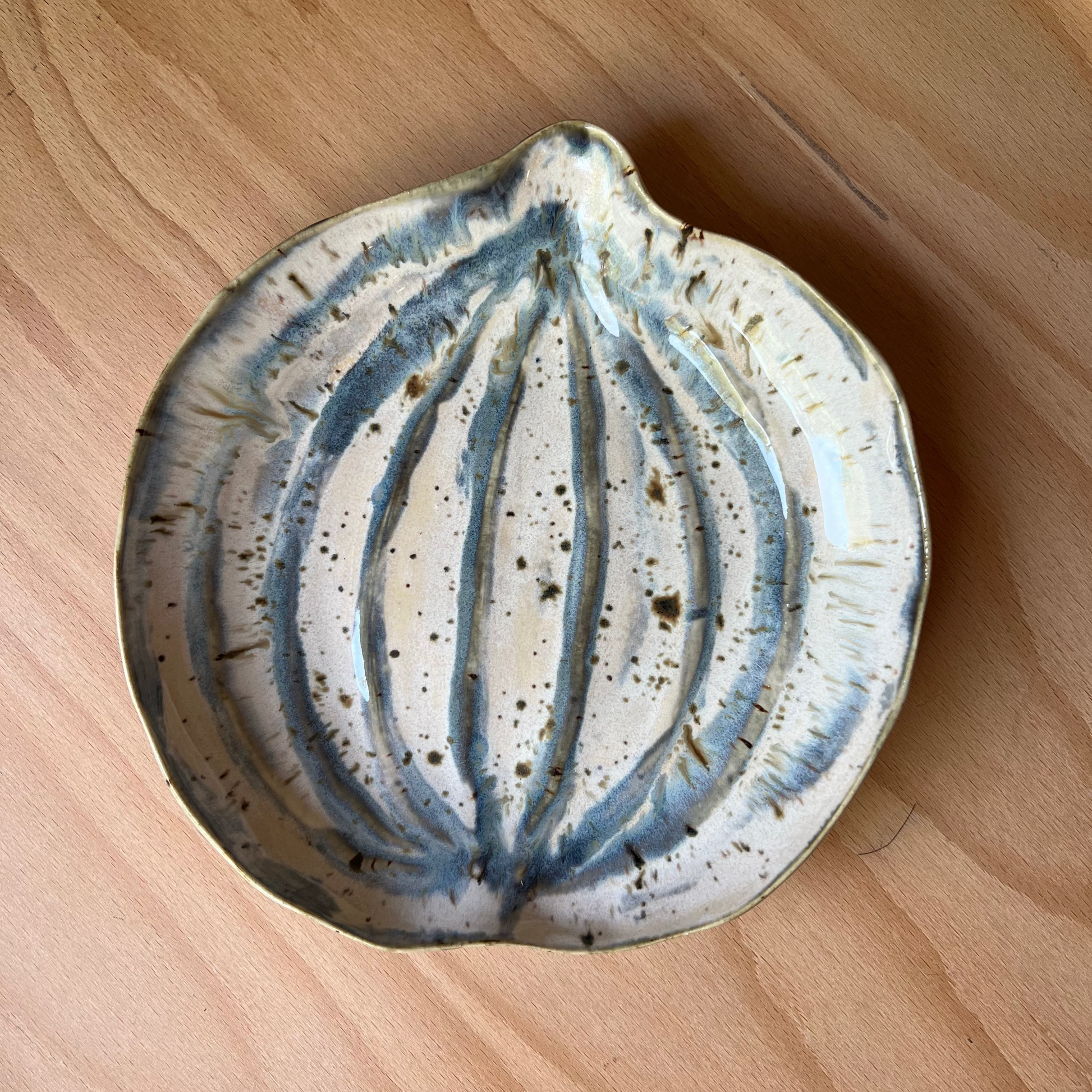 Ceramic pumpkin dish with blue and white design on a wooden surface