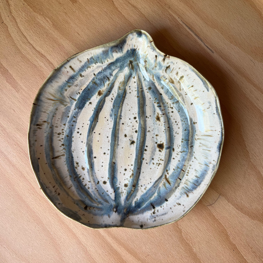 Ceramic pumpkin dish with blue and white design on a wooden surface