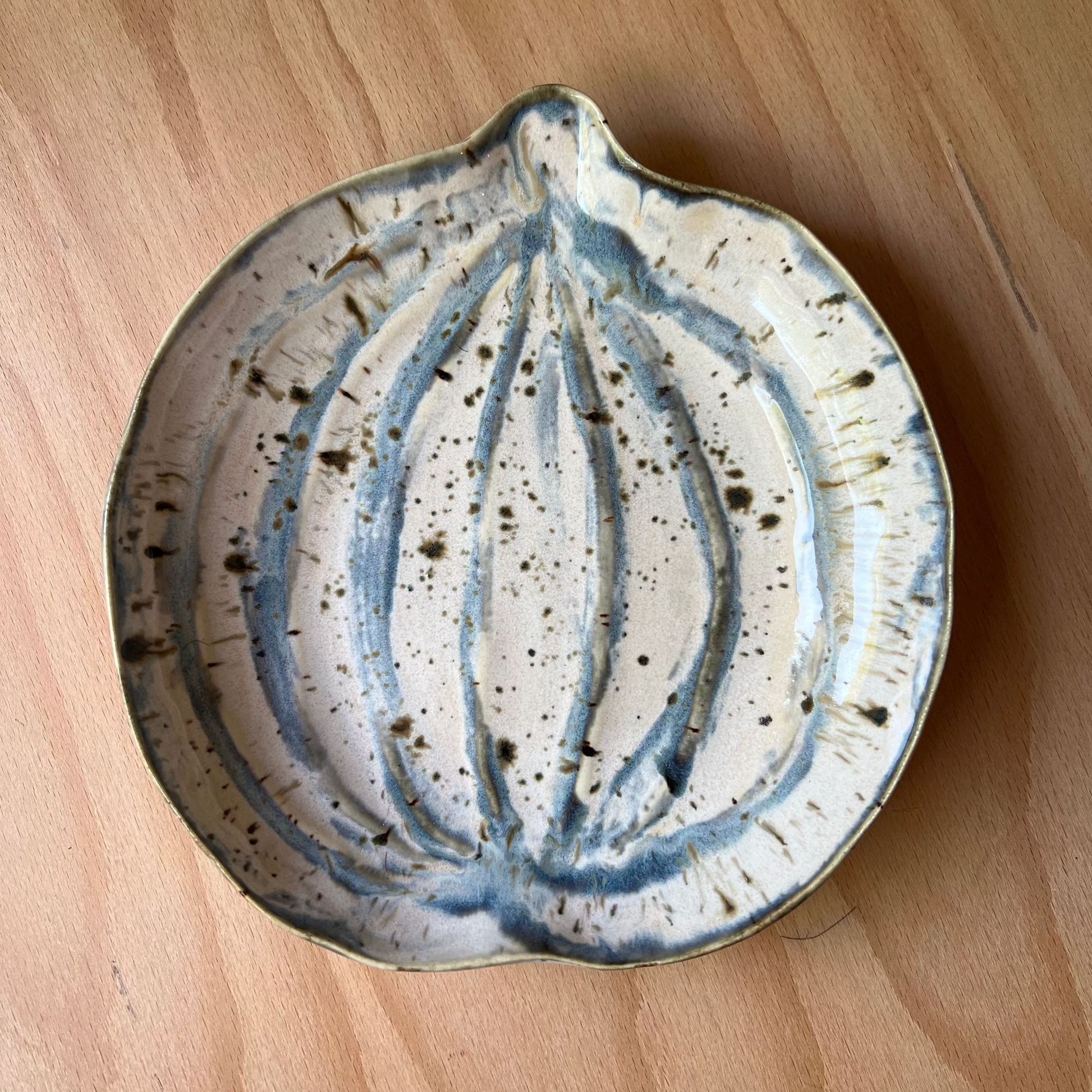 Ceramic pumpkin plate with blue and white design on a wooden surface