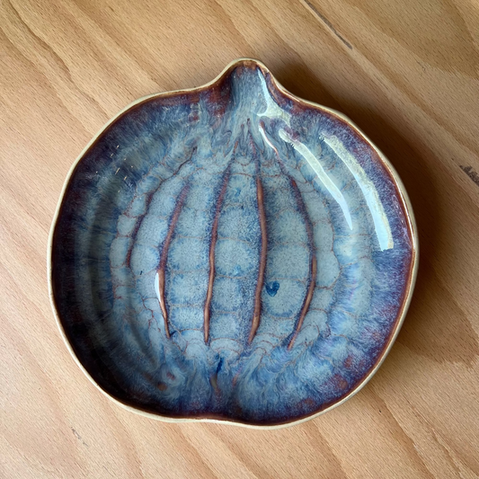 Ceramic dish with blue glaze on a wooden surface